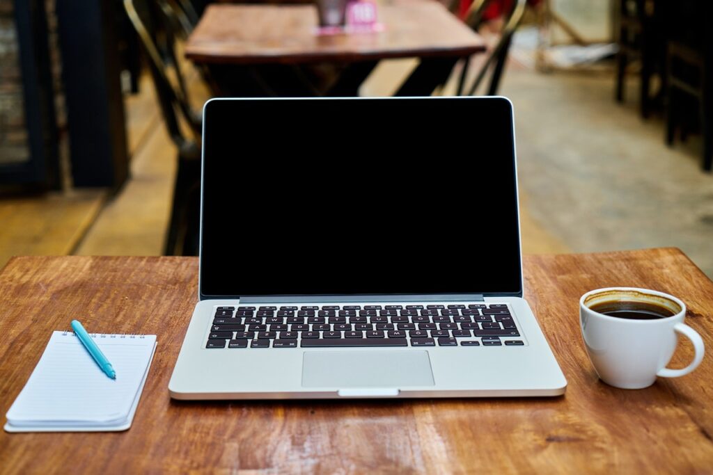 Laptoptisch mit Kaffeetasse und Notizblock
