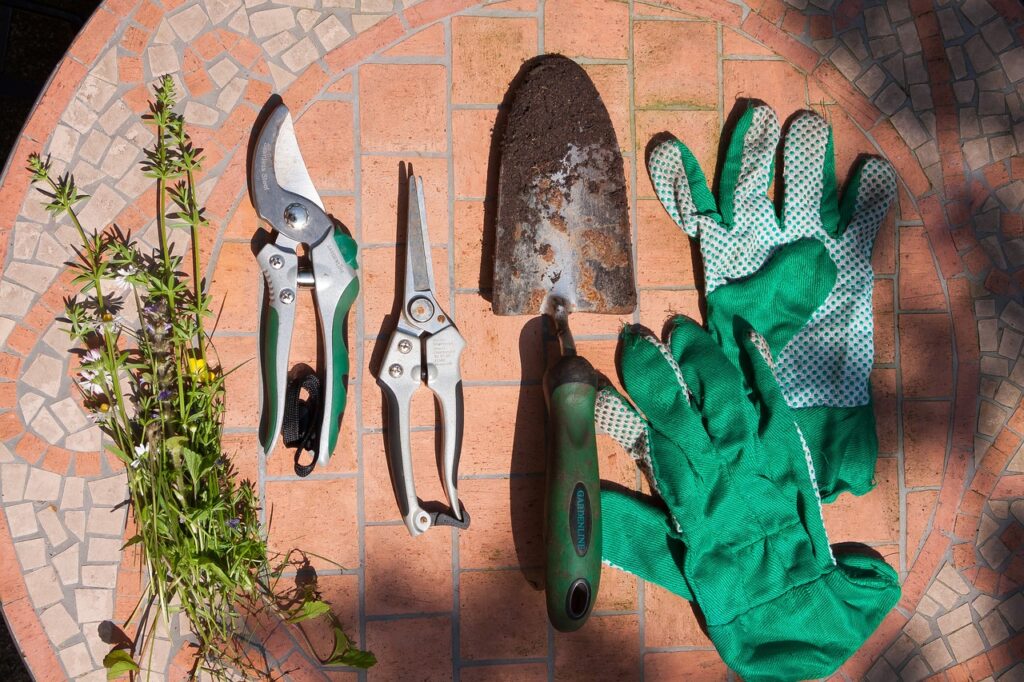 Grüne Arbeitshandschuhe und Gartenwerkzeuge